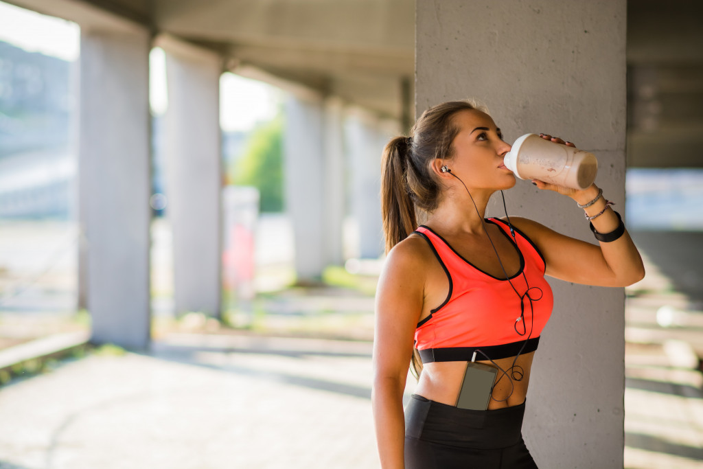 woman drinking after a run