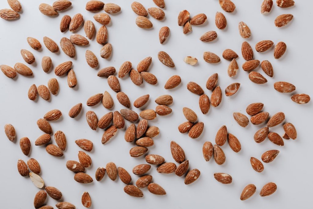 Scattered almonds placed on white background